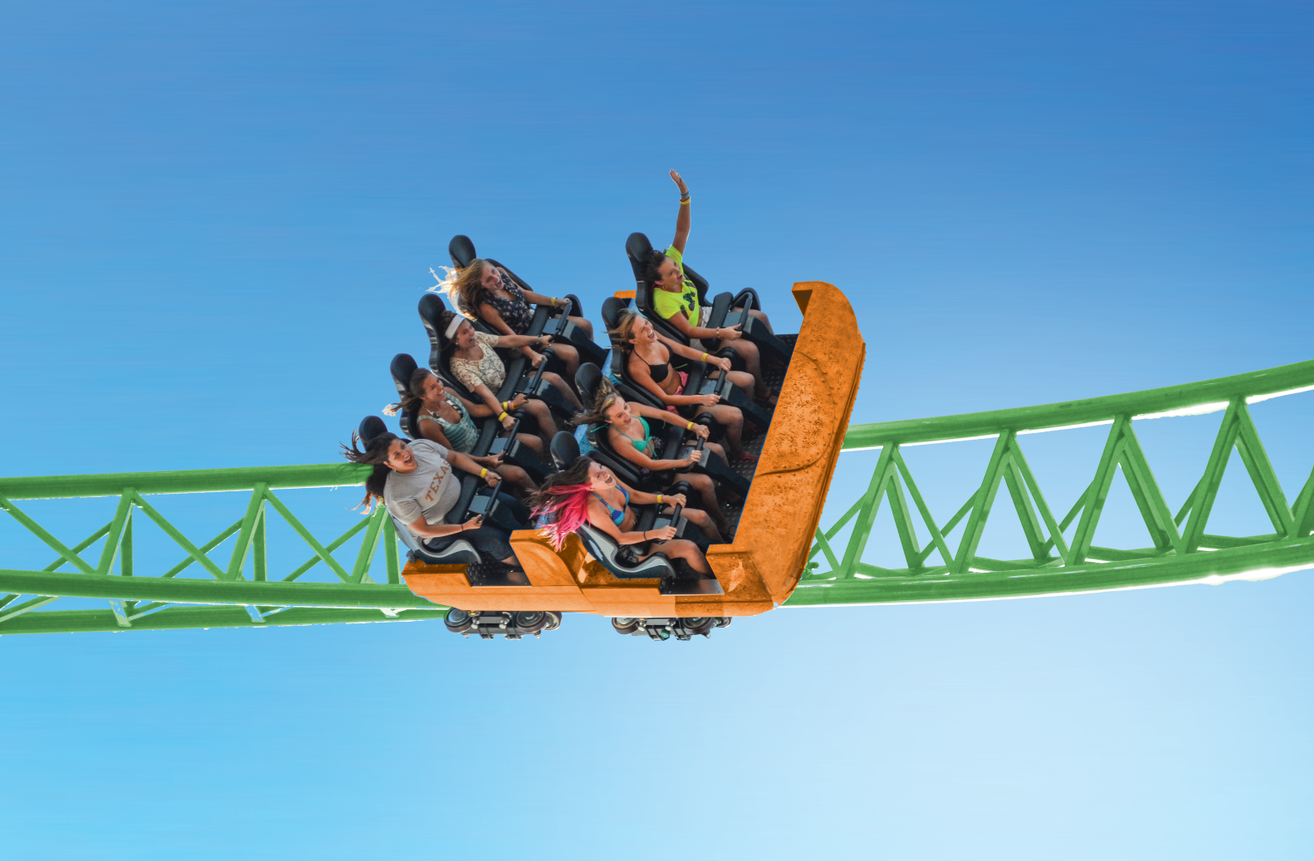 People riding on a coaster with their hands in the air.