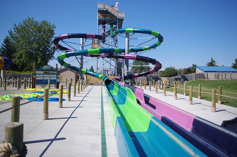 Two twisting water slides leading into a swimming pool.