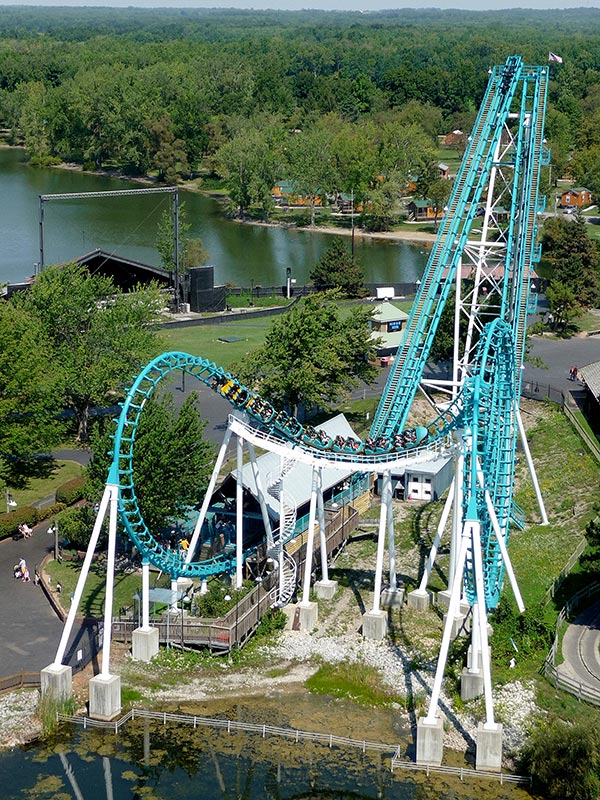 People riding a turquoise roller coaster.