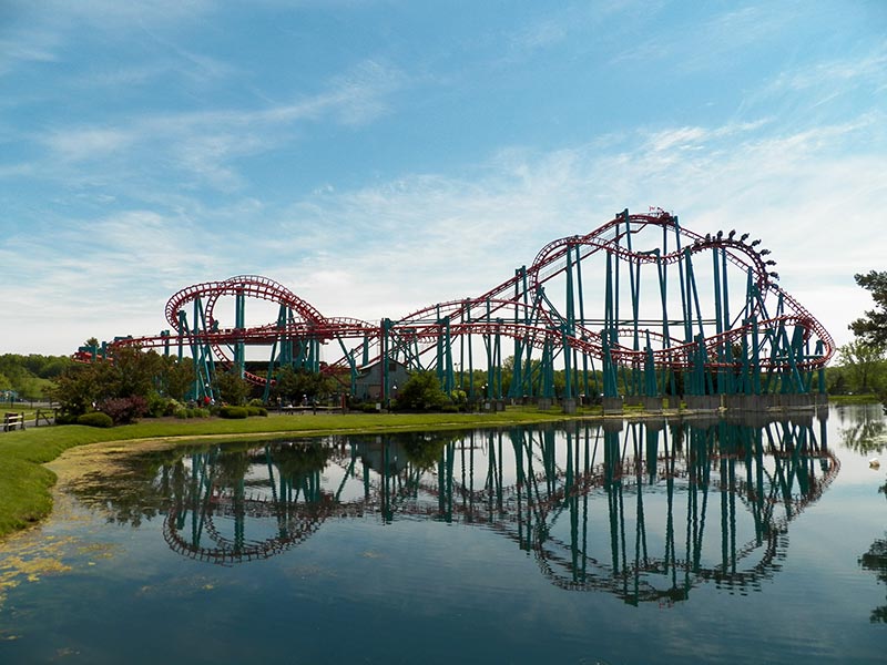 Roller coaster in front of body of water.