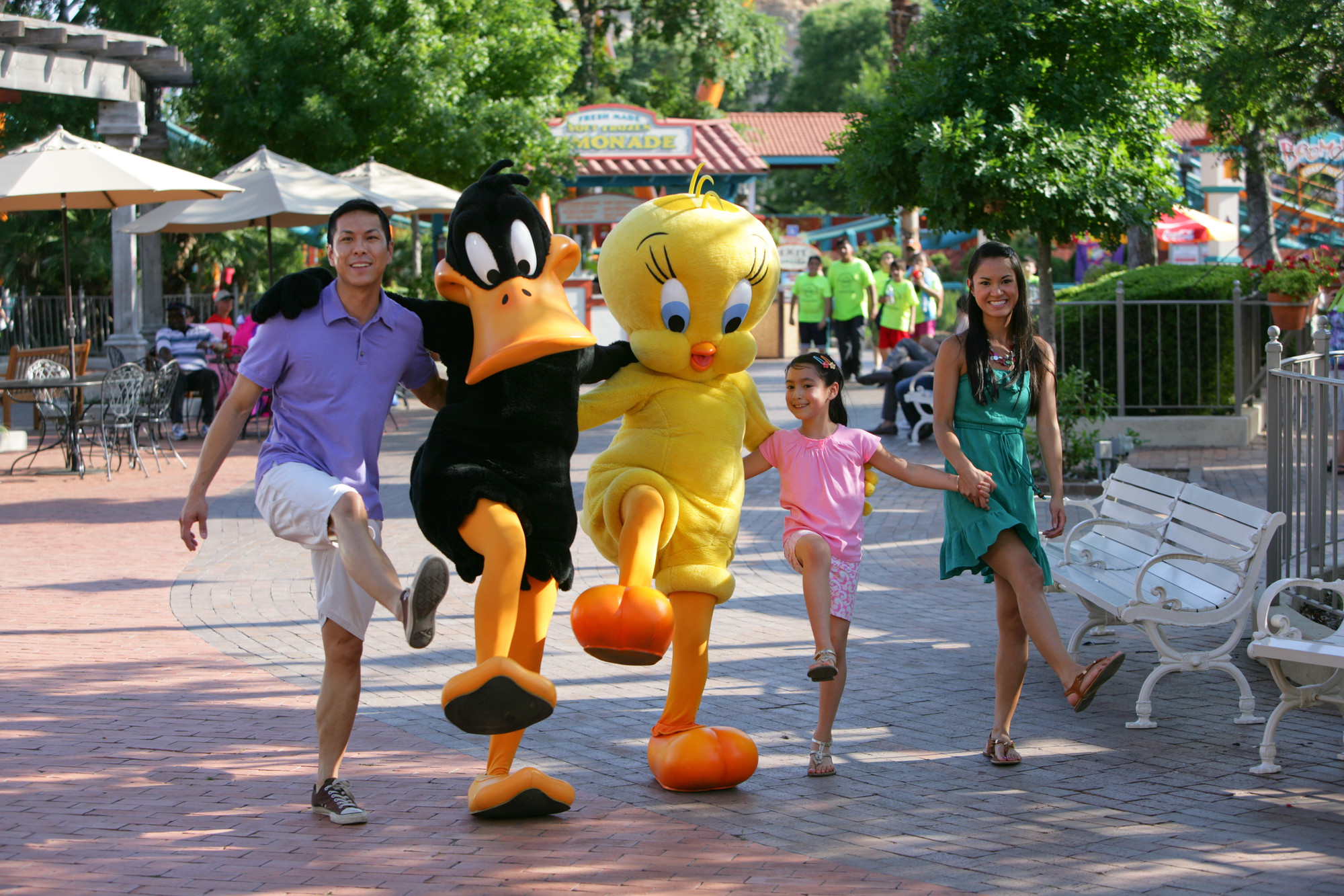 A family walking with characters at Six Flags theme park